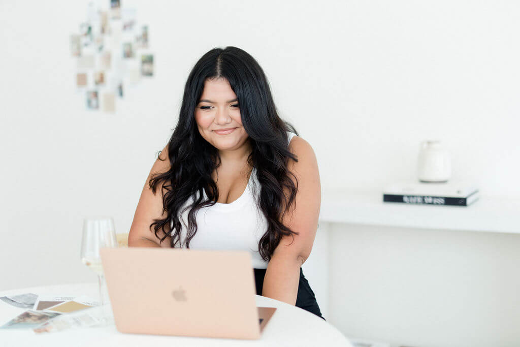 Designer sitting at a desk looking at her Macbook Air 